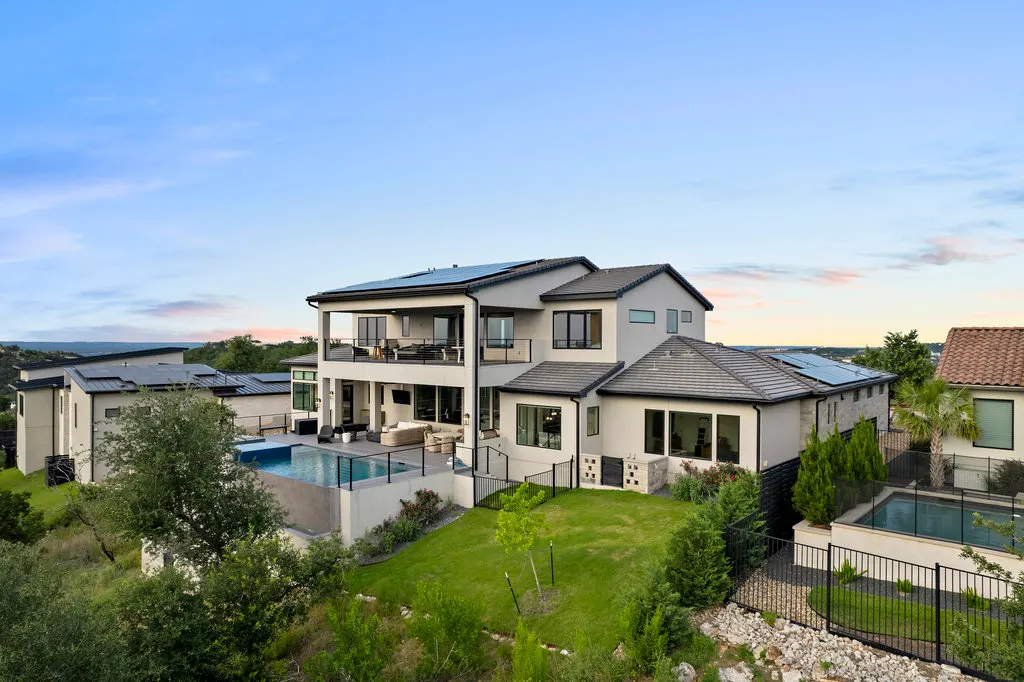 The house and lit pool from above at dusk in the Hill Country