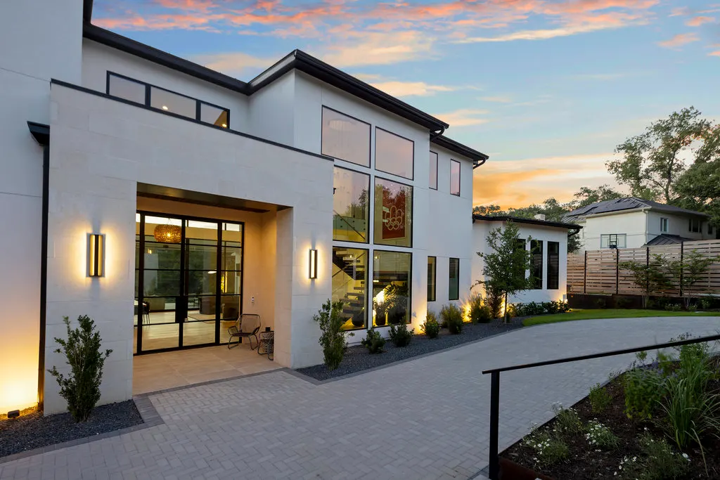 The lit entry court of a modern Westlake estate at dusk