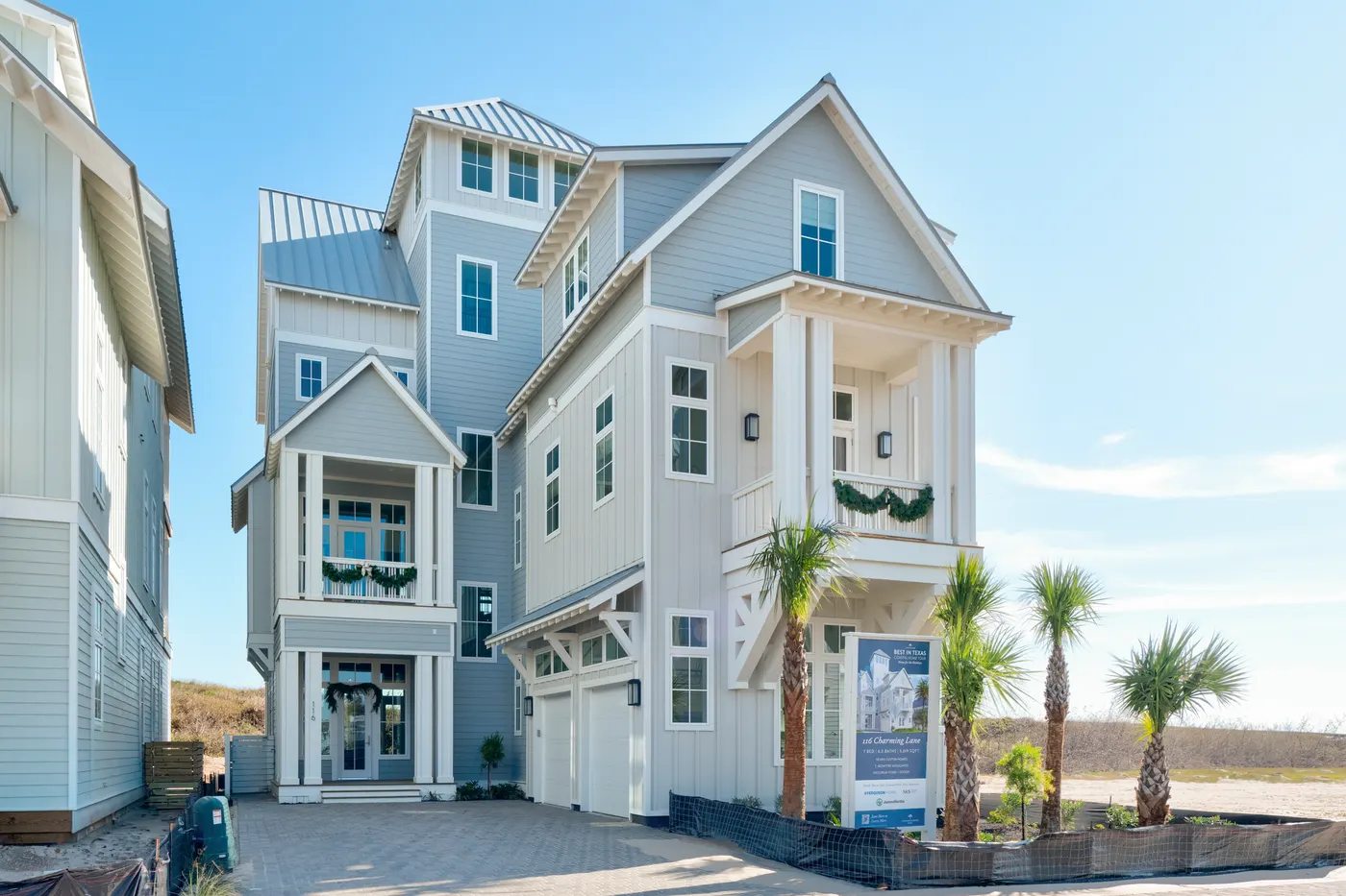 A three-story Port Aransas beach house behind palms