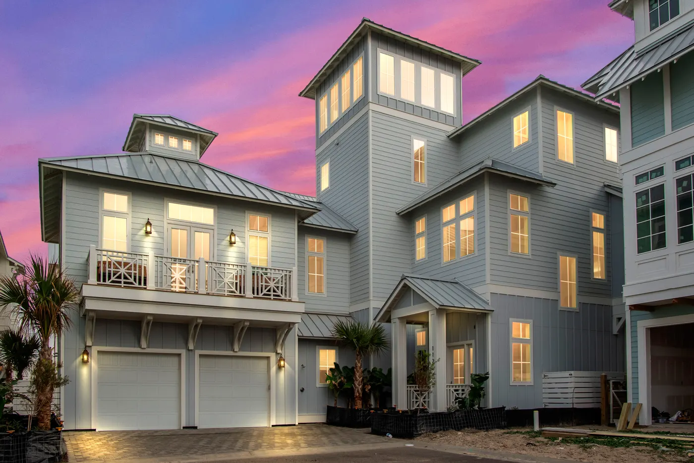 A sculptural coastal home lit at dusk