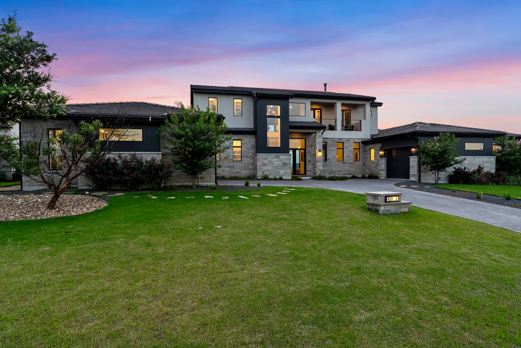 Backyard, terrace and lawn lit at dusk in the Hill Country