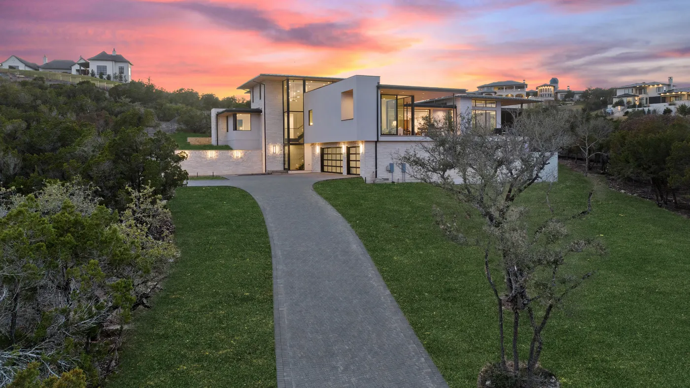 A Seven Custom Homes residence at sunset at the end of its drive