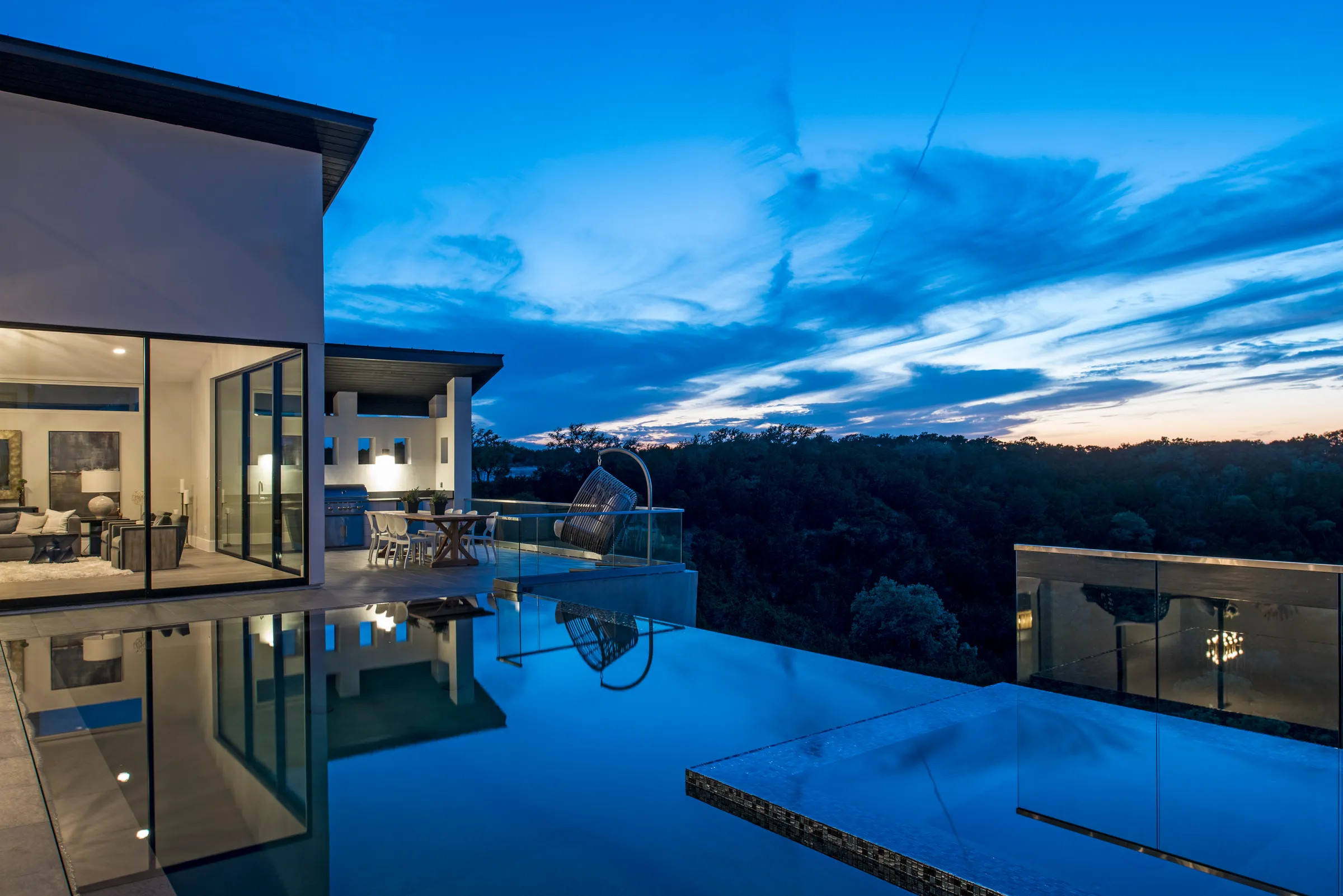 A Seven Custom Homes residence at night above its pool — Austin, Texas