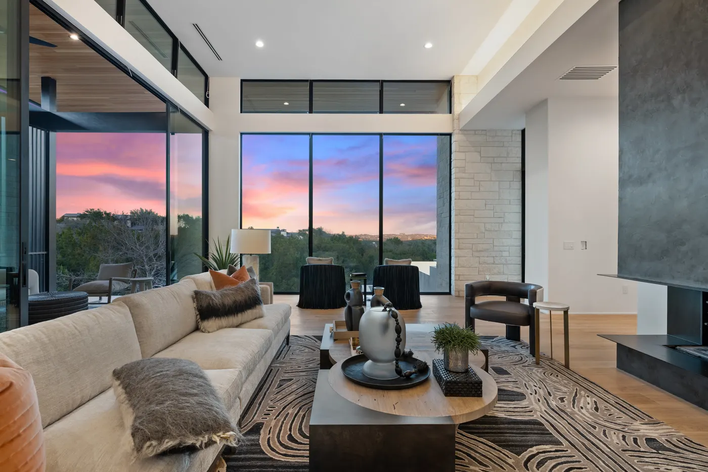 A living room behind a full wall of glass at sunset