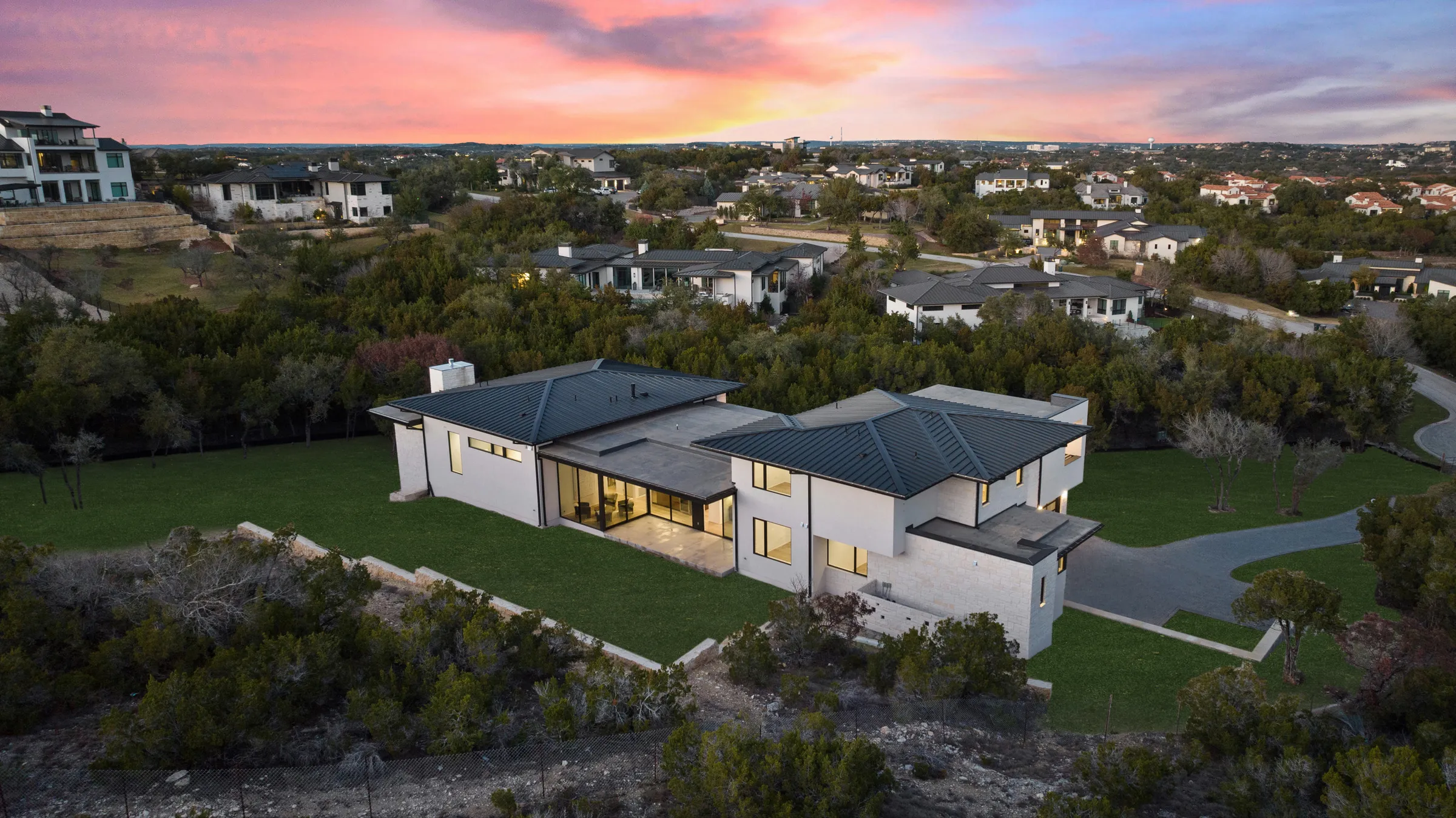 A Seven Custom Homes residence on a Hill Country ridge at dusk — Barton Creek, Austin