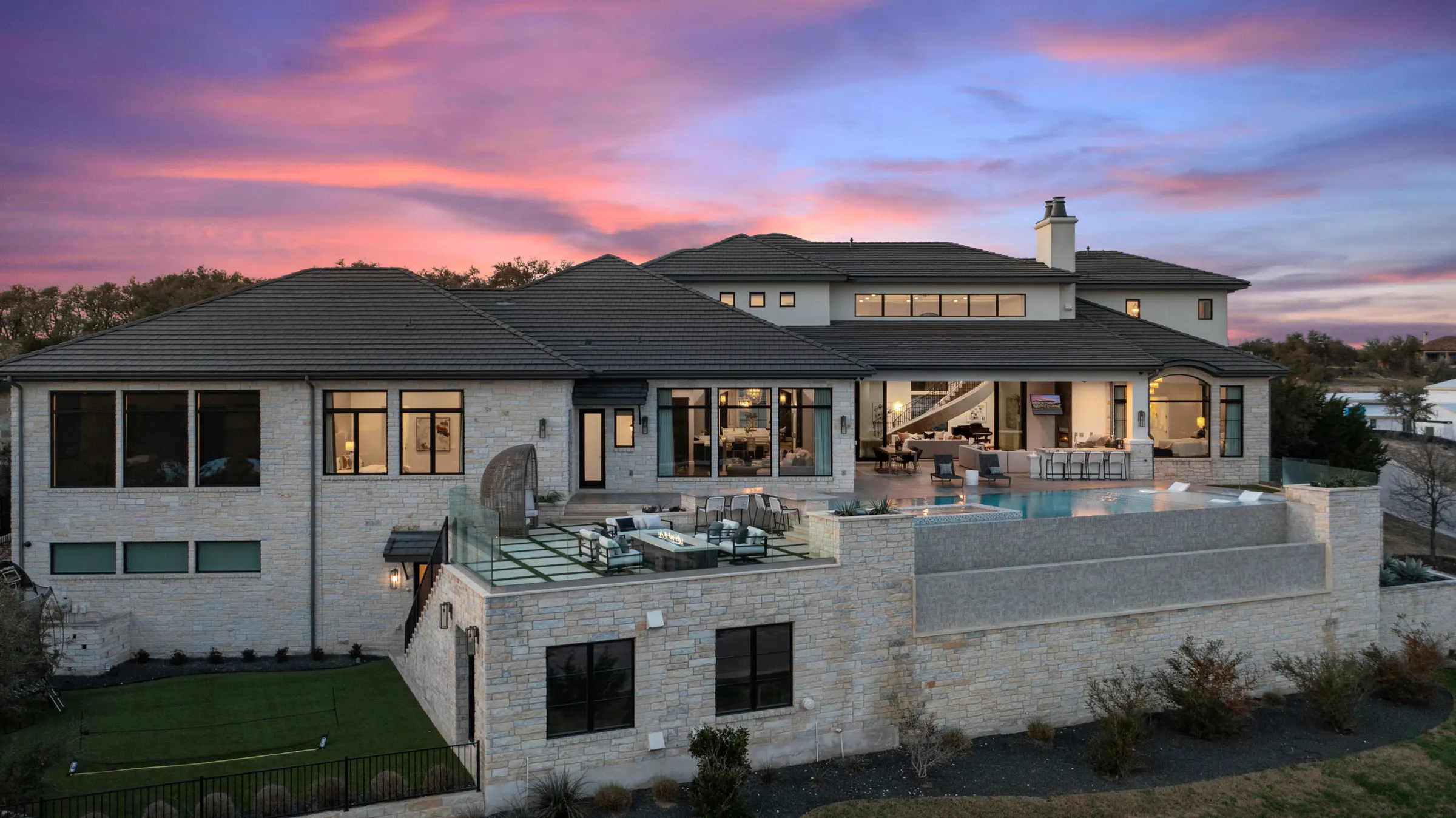 A Seven Custom Homes limestone estate above Lake Travis at dusk