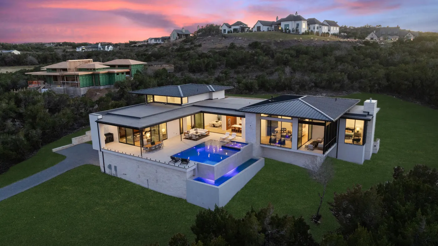 The estate from above at dusk, pool lit